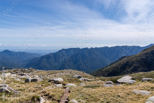 Mountain trail winding through Corsican landscape under sky