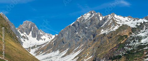 beautiful rocky peak mountains peaking  at spring with some snow under blue skiy in the French Alps in Tarentaise valley