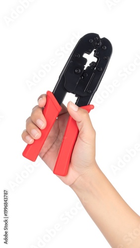 Close-up of a hand holding a red and black crimping tool against a white background, highlighting its design