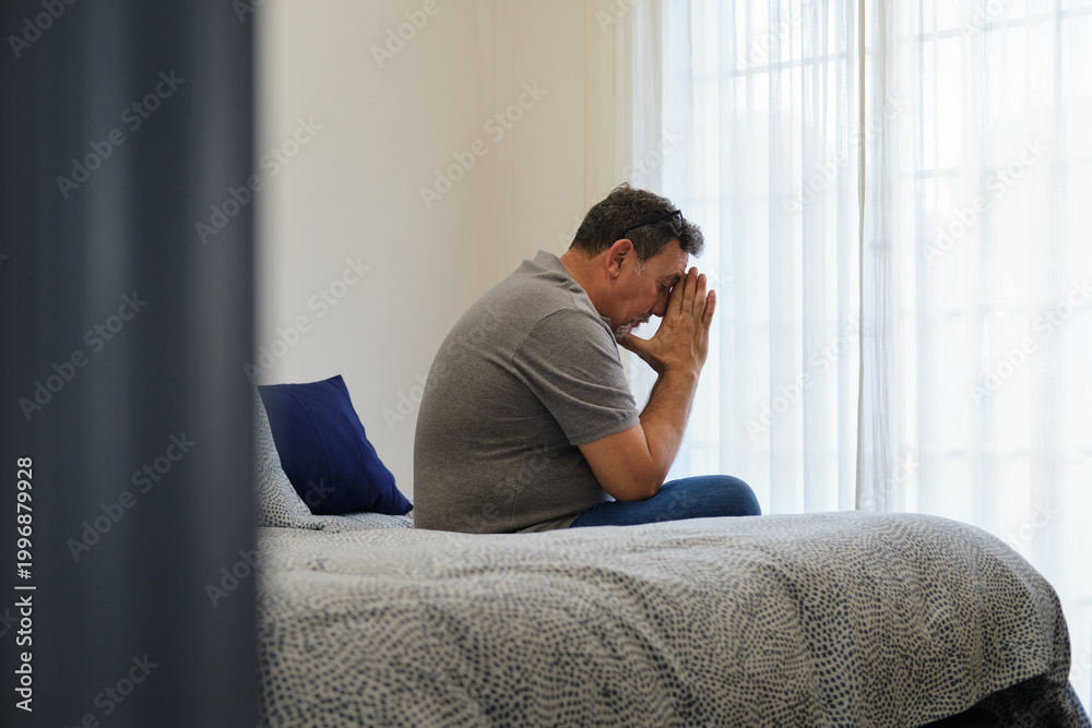 Fototapeta premium general view of Mature man feeling stressed and worried sitting on bed