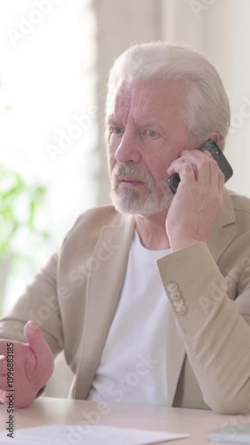 Old Man Talking on Phone in Office, Vertical Video
