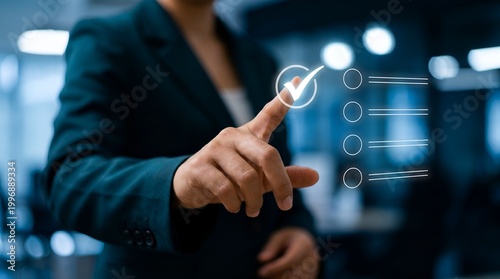 A businesswoman in a suit interacts with a digital interface, touching a checkmark icon with her finger in a modern office setting.