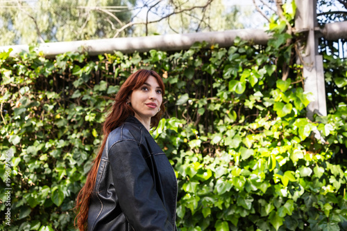 Red-haired woman in a park in the city.