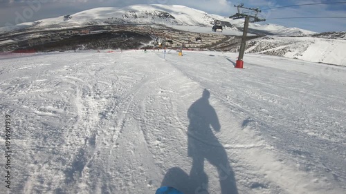Pov Snowboarder On Alpine Slope, Shadow Cast Across Groomed Snow, Chairlift And Mountain Ridgeline In Background, Carved Tracks And Moguls, Crisp Winter Light, Lone Rider Carving Gentle Descent,