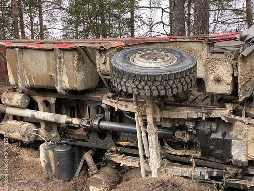 Fotografía Close view of an overturned truck undercarriage covered with mud