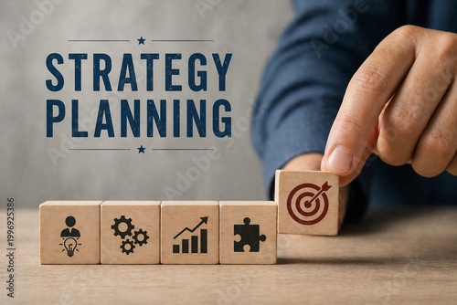 A hand places a wooden block with a target symbol on a row of strategy planning blocks on a desk.