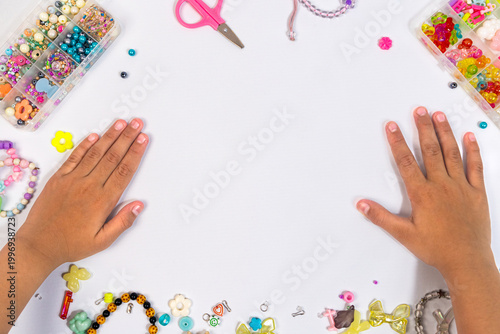 Child's hand with beads scissor string and bracelet, craft creativity concept background wallpaper