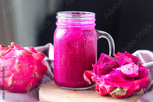 Foto A glass jar of dragon fruit juice with a vibrant pink color, served with fresh fruit pieces