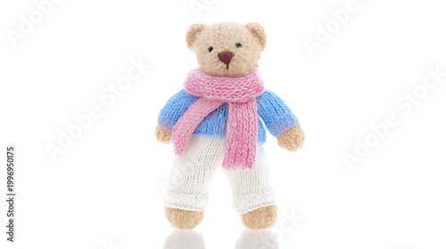 Adorable knitted teddy bear wears pink scarf blue sweater