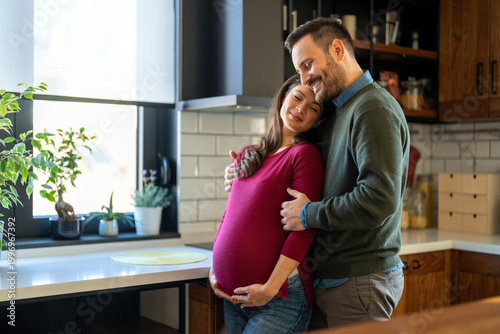 Man in love hugs his pregnant wife, they are waiting together for the baby's arrival. Love, family