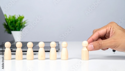 Hand lifting wooden peg figure from group.