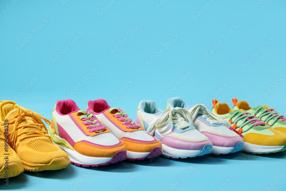 Fototapeta premium Stylish bright sneakers on light blue background, closeup