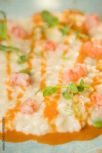 Gourmet presentation of a traditional Italian seafood risotto served on an elegant restaurant plate. The image captures the rich, creamy texture of the perfectly cooked rice beautifully combined with 