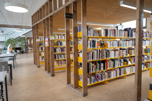 Modern public library interior with bookshelves, reading and study space