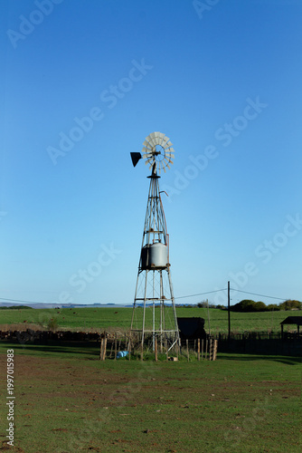 A windmill for extracting water from the ground in the middle of a field