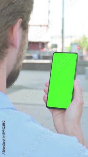 Man Using Smartphone with Green Screen Outdoor, Vertical Video
