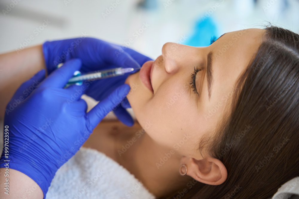 Fototapeta premium Injection procedure for lip augmentation, close up