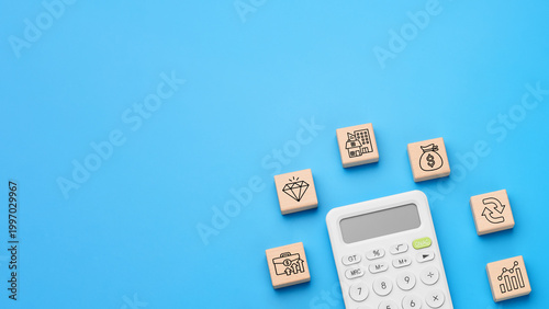 Calculator with wooden blocks and investment icons for capital growth