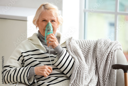 Senior woman using nebulize...