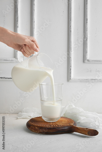 Woman pouring kefir from ju...