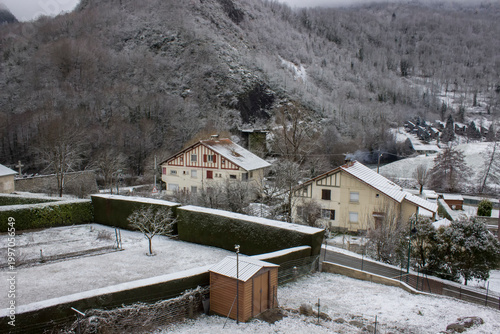 houses between the mountains in the snow and clouds