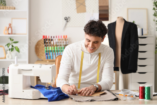 Young male tailor using sew...