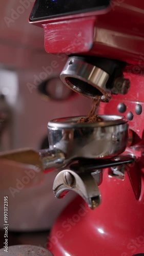 Coffee beans being ground into a portafilter on an espresso machine. Coffee preparation in a cafe