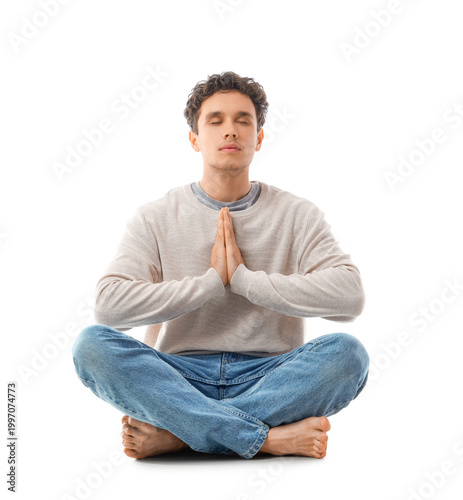 Young man meditating on whi...