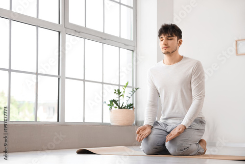 Young man meditating on yog...