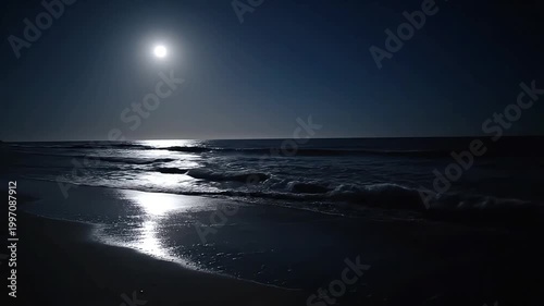 Serene ocean waves gently lap the shore under a luminous full moon.