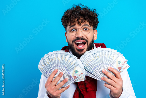 Quadro em tela Excited young man holding fanned US dollar cash, showing wealth and financial su