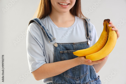 Young woman with bananas on...
