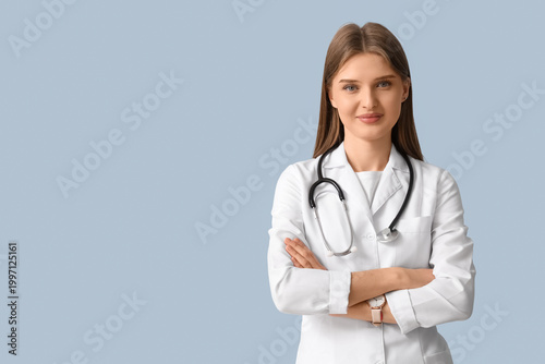 Beautiful young doctor on blue background