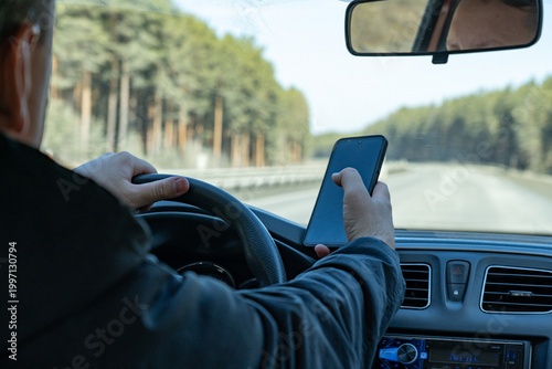 Canvastavla A Driver Using a Smartphone While Navigating a Scenic Road Surrounded by Trees,