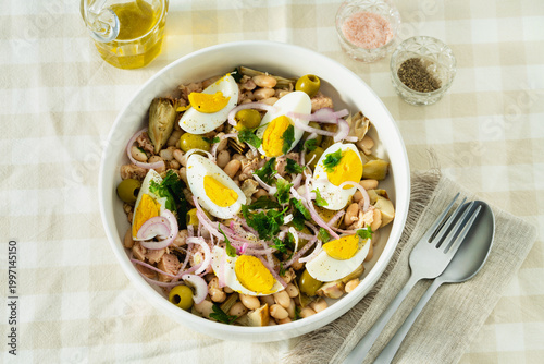 Valokuva Cannellini Bean Salad with Tuna and Eggs on Checkered Tablecloth with Olive Oil