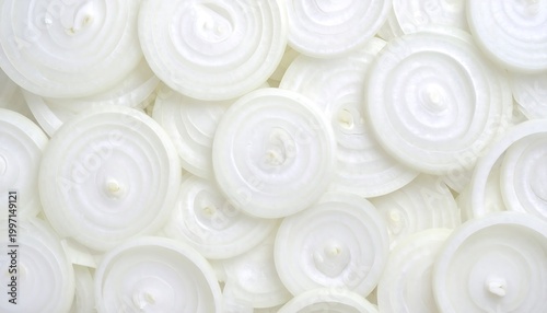 Overhead shot of many freshly cut, translucent onion rings, layered randomly, showcasing intricate textures
