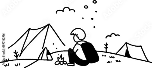 Person sitting by campfire facing tents on hillside campground