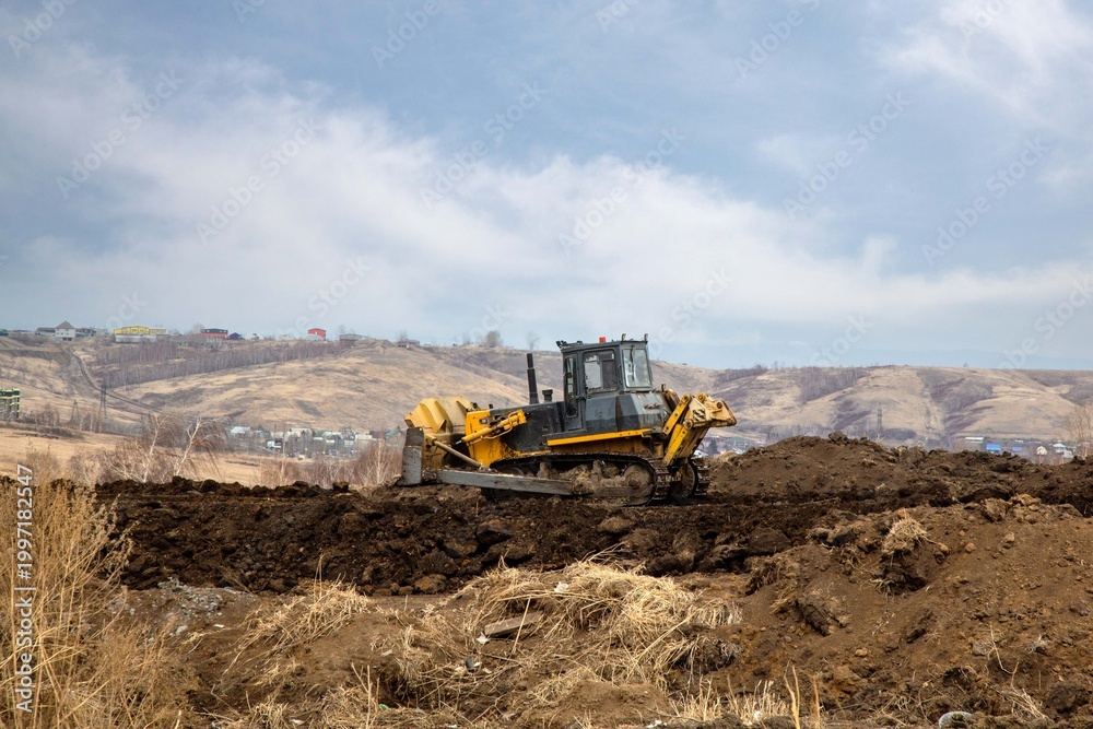 Obraz premium A bulldozer works on the construction of a new road. Construction equipment.