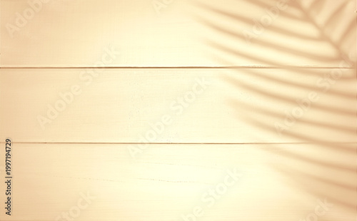 Minimal warm wooden background with soft sunlight and tropical palm leaf shadows creating a calm and natural atmosphere. Light beige tones and smooth texture make this image ideal for modern branding