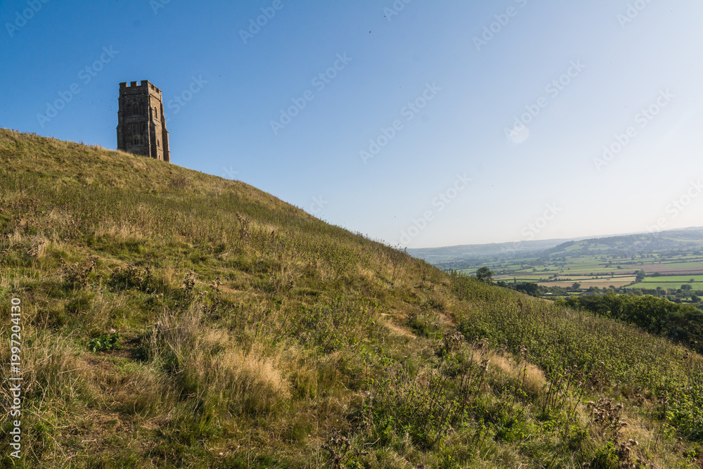 Fototapeta premium Historic St Michaels Tower on Glastonbury Tor Hill under Clear Blue Sky 
