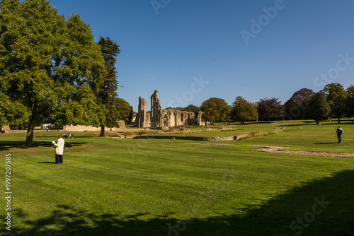 Ancient Ruins of Glastonbury Abbey with Gothic Arches under a Clear Blue Sky
