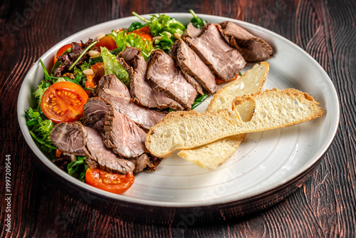 Roast beef salad with bread and fresh greens
