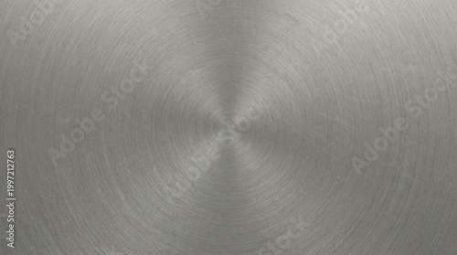 Brushed metal texture background with circular pattern stainless steel surface with radial scratches and metallic sheen for industrial design or technology concepts