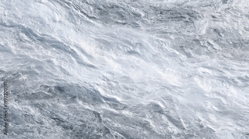 Abstract, textured surface of a light blue/grey material, with flowing, wave-like patterns and subtle shading