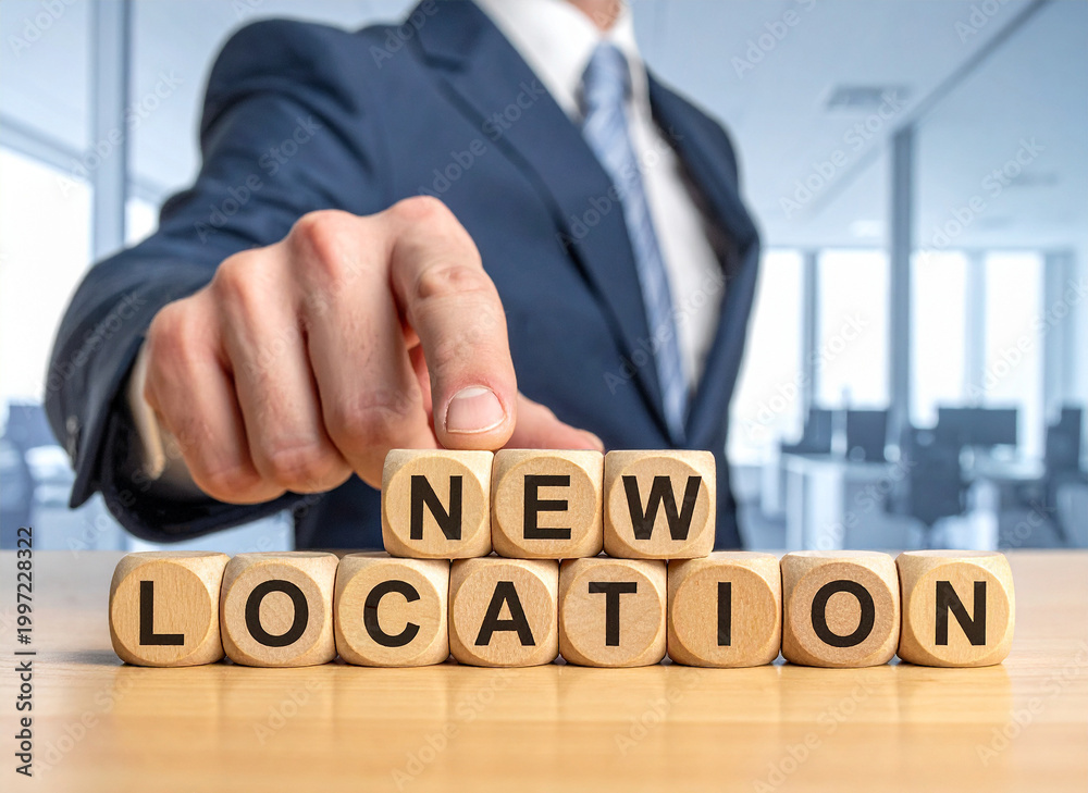 Obraz premium New Location - Geschäftsmann zeigt auf den Text 