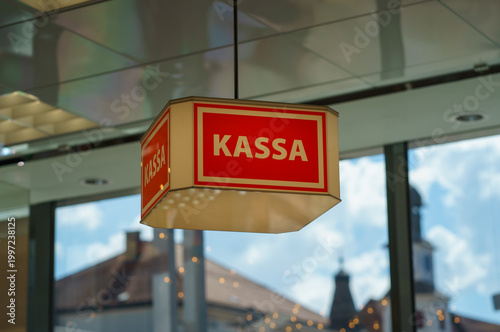Tableau sur toile Close-up of red cash register sign reading Kassa inside modern shop, with blurre