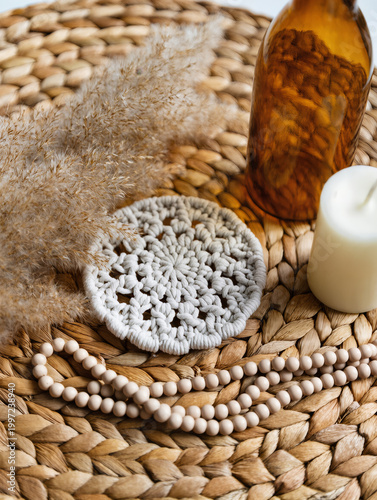 Boho Decor Flatlay with Macrame Coaster, Pampas Grass, Amber Glass Bottle, Ceramic Beads and Neutral Candle on Woven Rattan in Soft Natural Light