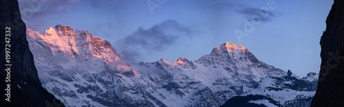 Fotografie Panorama de montagnes enneigées au lever du soleil avec lumière alpine rose