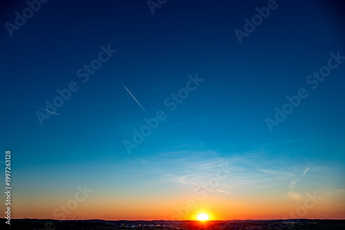 Fotografie Kondensstreifen am Himmel bei Sonnenuntergang