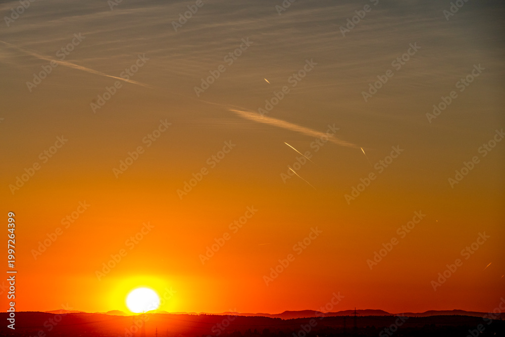 Fototapeta premium Kondensstreifen am Himmel bei Sonnenuntergang